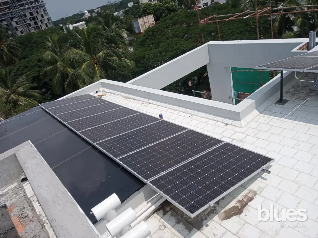 Two rows of solar panels on a raised terrace structure in Mudichur