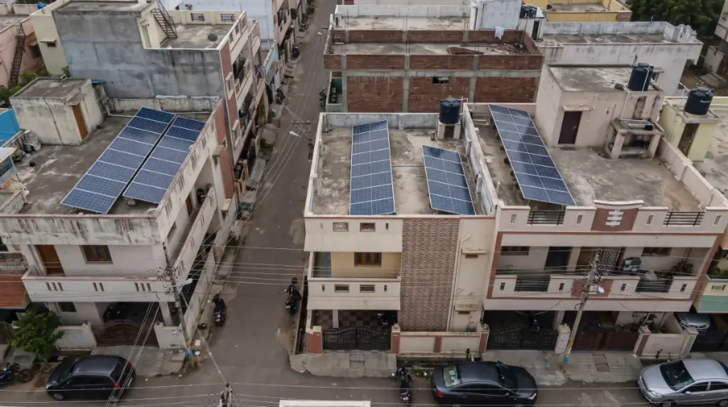 Aerial view of rooftops in Hosur with solar panels on several terraces