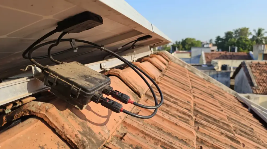 A close-up of a solar panel junction box and MC4 connectors on the underside of a module, rooftop solar in Thirumullaivoyal